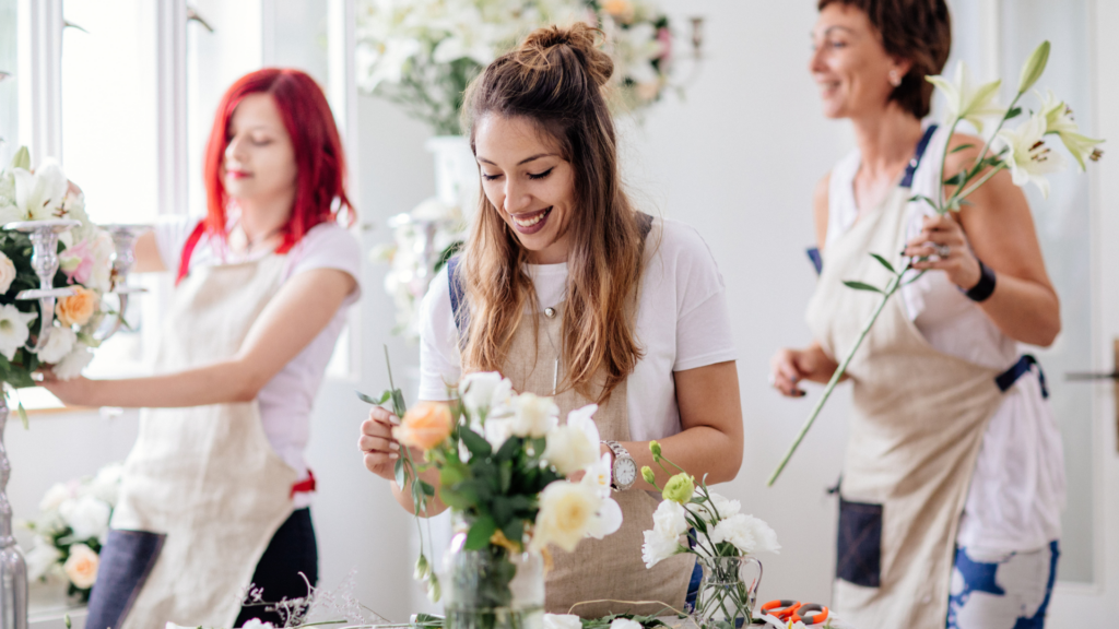 A florist setting up a beautiful floral arrangement at a photoshoot location.