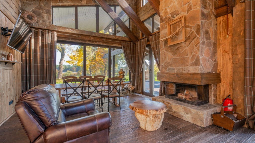 A rustic-style living room with wooden beams and stone fireplace.